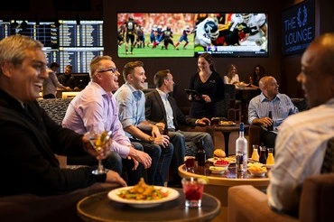 group of people seated watching sports games in a sports book