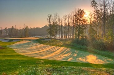 Morning sun shining on the Kaluhyat golf course through the woods