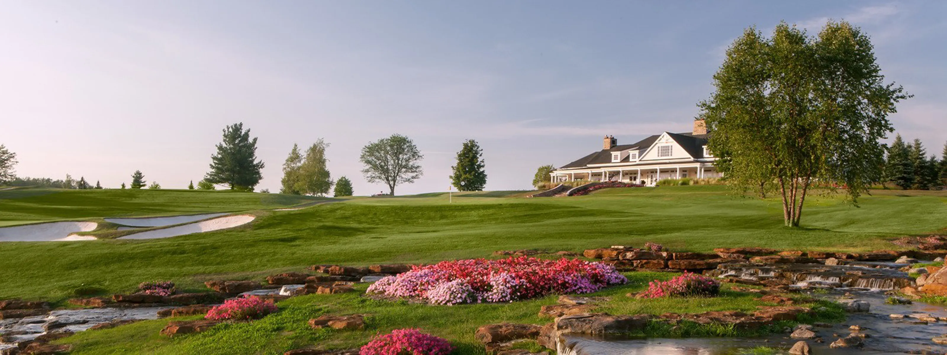 Panoramic view of Atunyote - an award winning  golf course with flowers and water stream and Clubhouse at Turning Stone Resor