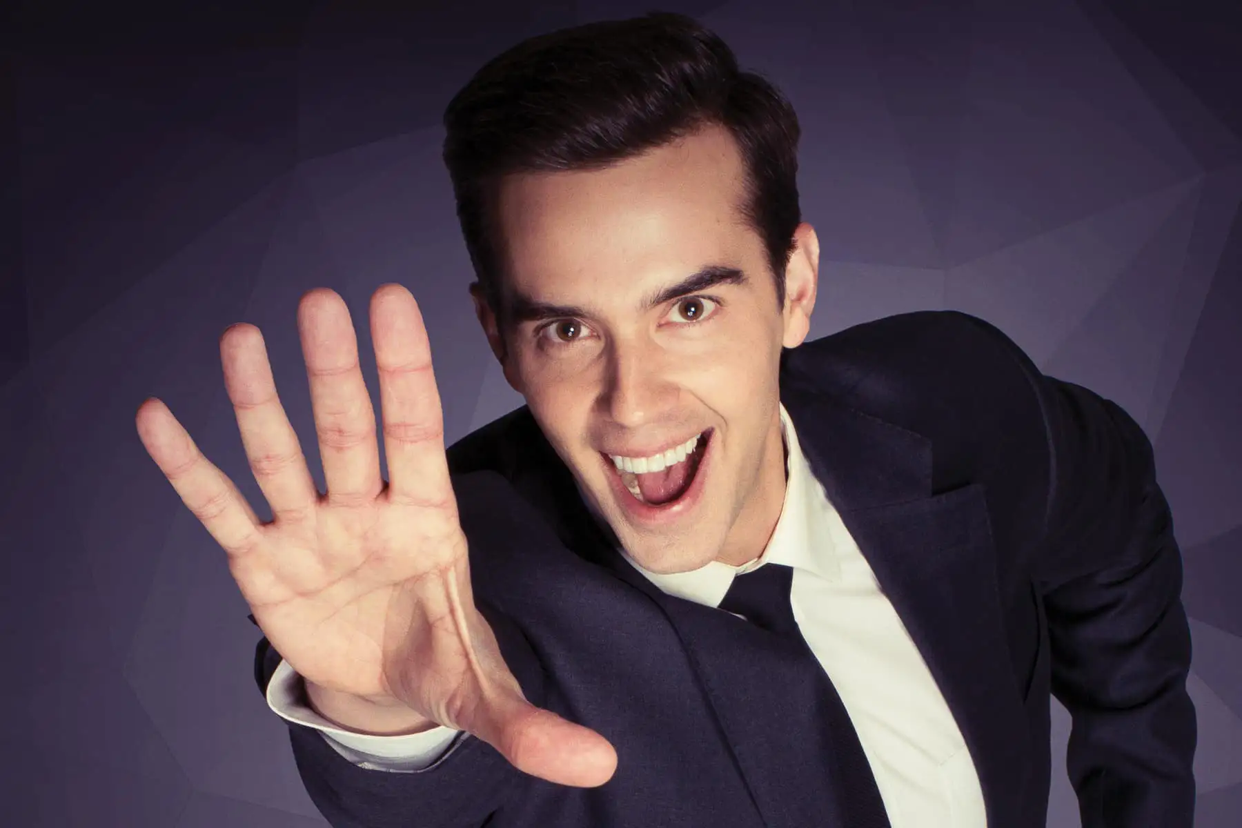 Michael Carbonaro with hand outstretched towards the camera